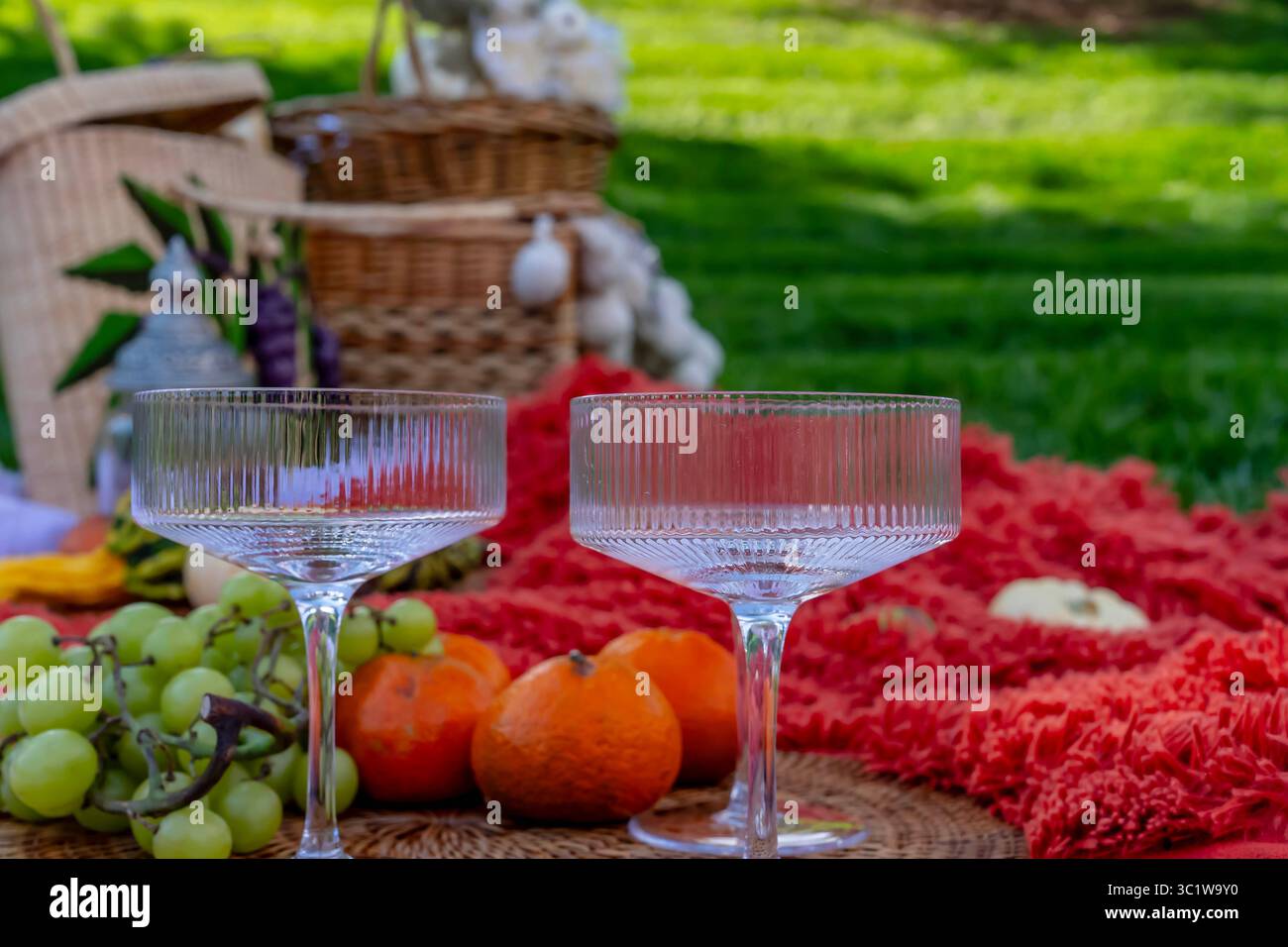 Ein lebhaftes Picknick im Herbst bietet farbenfrohe saisonale Speisen – helle Kürbisse, Äpfel, Wurstwaren, frisches Brot, Käse, und warme Getränke. Umschlossen b Stockfoto