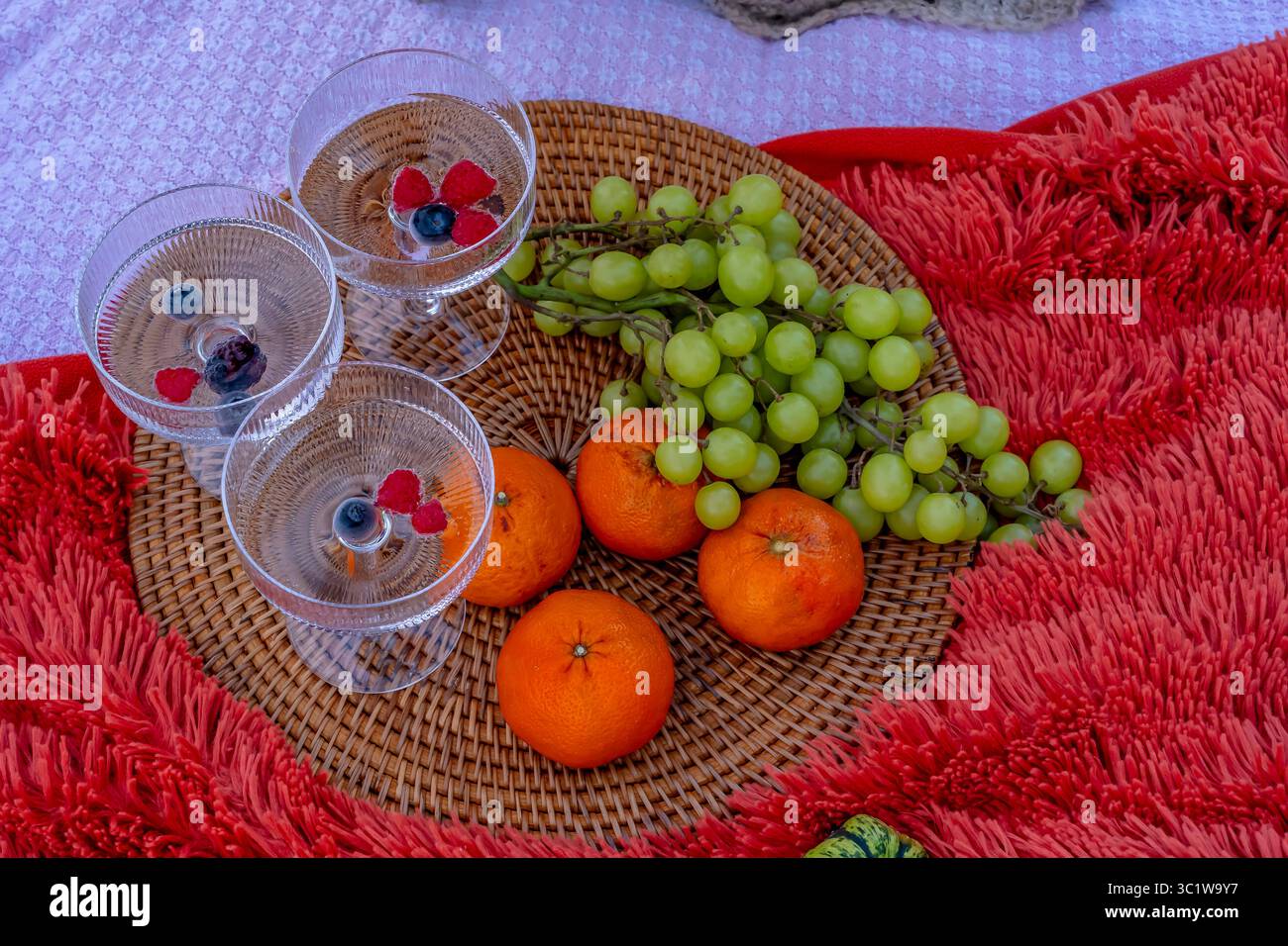 Ein lebhaftes Picknick im Herbst bietet farbenfrohe saisonale Speisen – helle Kürbisse, Äpfel, Wurstwaren, frisches Brot, Käse, und warme Getränke. Umschlossen b Stockfoto