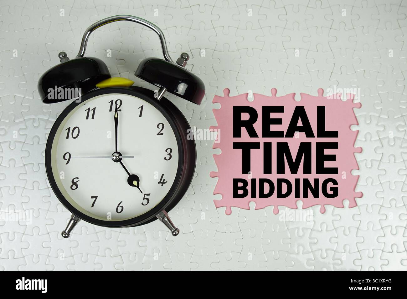 RTB-Text (Real Time Bidding) mit Wecker auf rosafarbenem Hintergrund Stockfoto