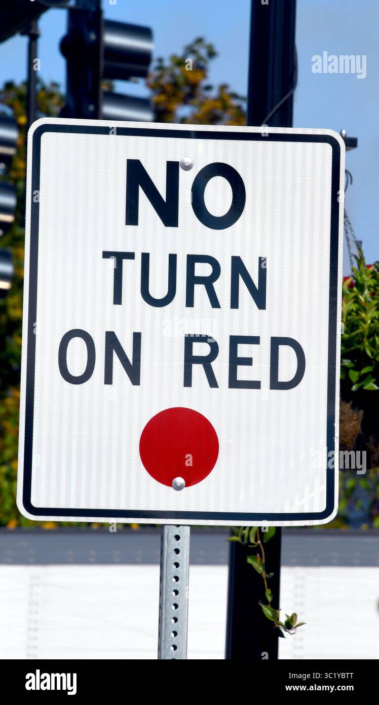 Ein weißes Metallschild mit schwarzem Buchstaben warnt Autofahrer, dass das Rot nicht eingeschaltet wird. Das Schild ist in Waterbury, Vermont. Stockfoto