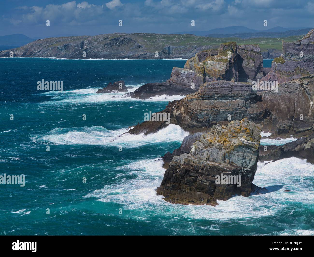 Atemberaubende Aussicht auf zerklüftete Klippen vor dem abstürzenden Atlantischen Ozean in Mizen Head, Irland, mit natürlicher Schönheit und Kraft. Stockfoto