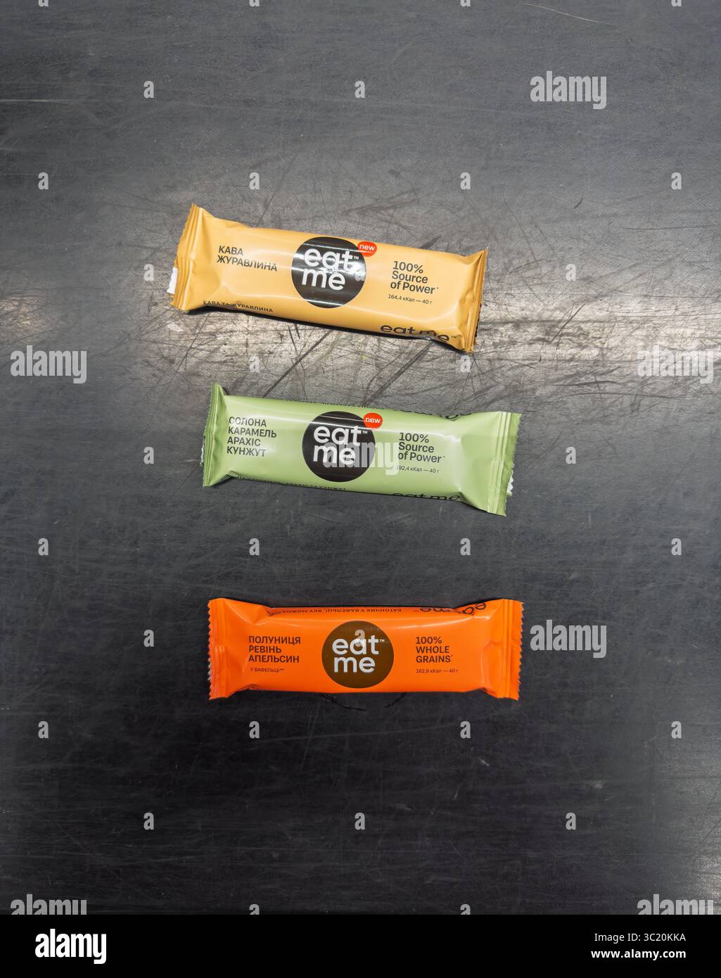 Kiew, Ukraine - 05. Juli 2025: Top-down-Ansicht von drei verschiedenen Snackbars von Eat Me Healthy auf einem dunklen strukturierten Hintergrund Stockfoto