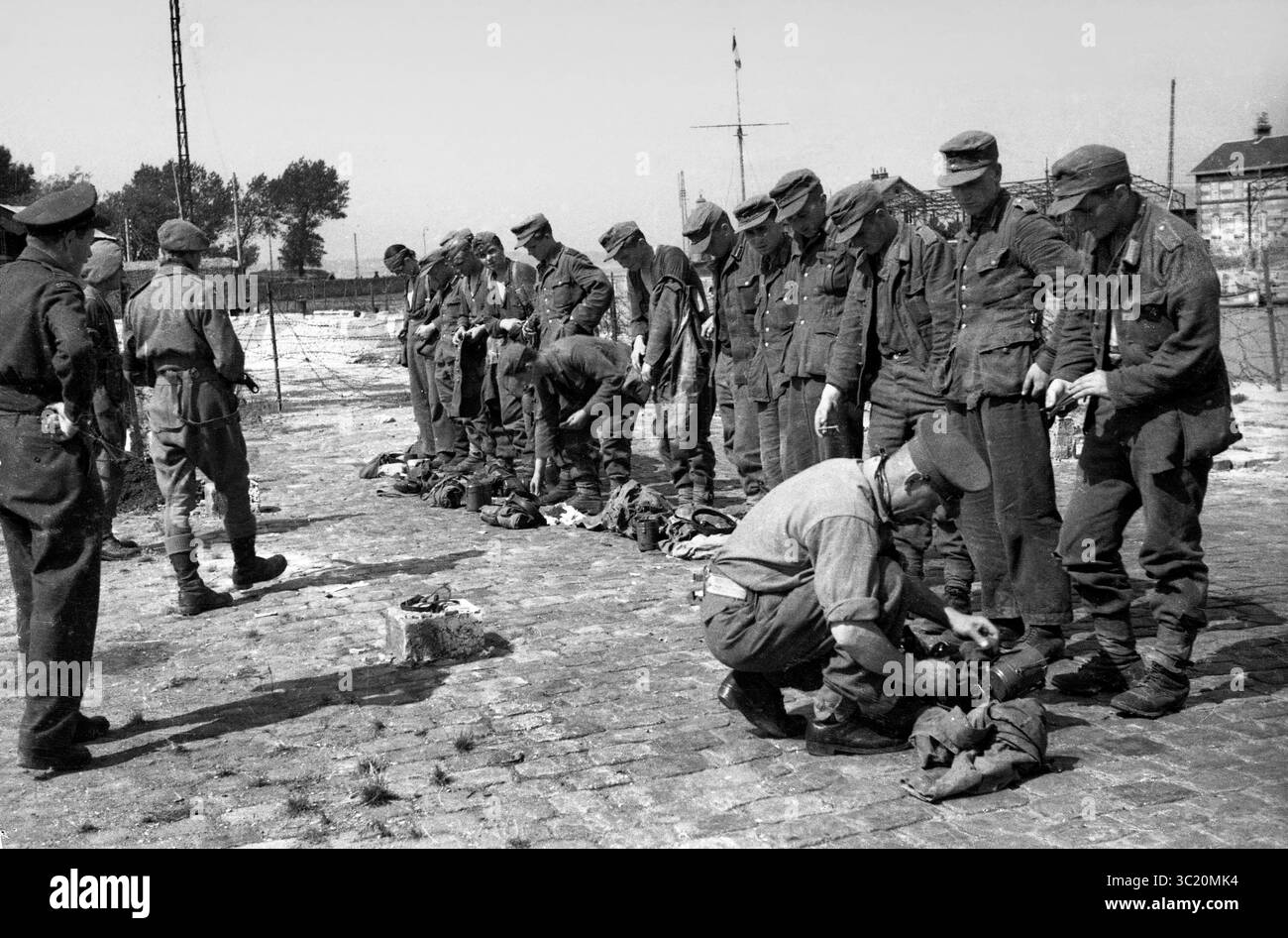 Die Befreiung von Honfleur, Normandie, Frankreich während des zweiten Weltkrieges. 26. August 1944. Britische und kanadische Soldaten suchen nach ihrer Kapitulation junge deutsche Soldaten. Stockfoto
