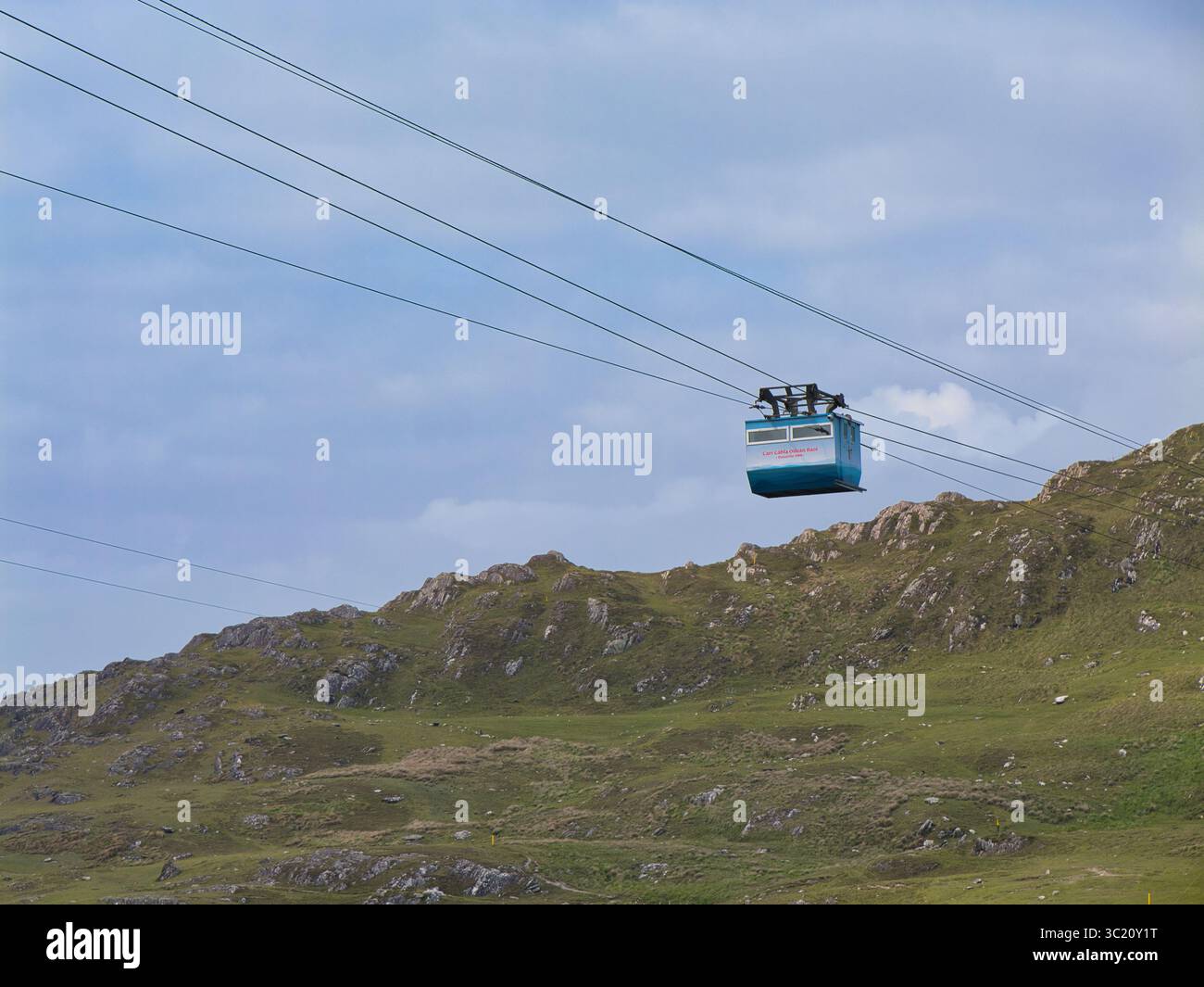 Dursey Island, Irland - 03. Juni 2025: Eine einsame Seilbahn durchquert eine zerklüftete Landschaft auf Dursey Island, Irland, eingebettet unter einem riesigen blauen Himmel. Stockfoto