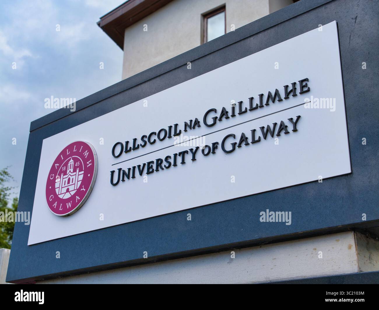 Galway, Irland - 13. Juni 2025: Nahaufnahme des University of Galway-Schilds mit dem markanten Wappen unter teilweise bewölktem Himmel. Stockfoto