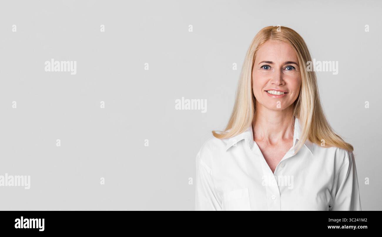 Lächelnde Frau mittleren Alters mit Blick auf die Kamera im Studio Stockfoto
