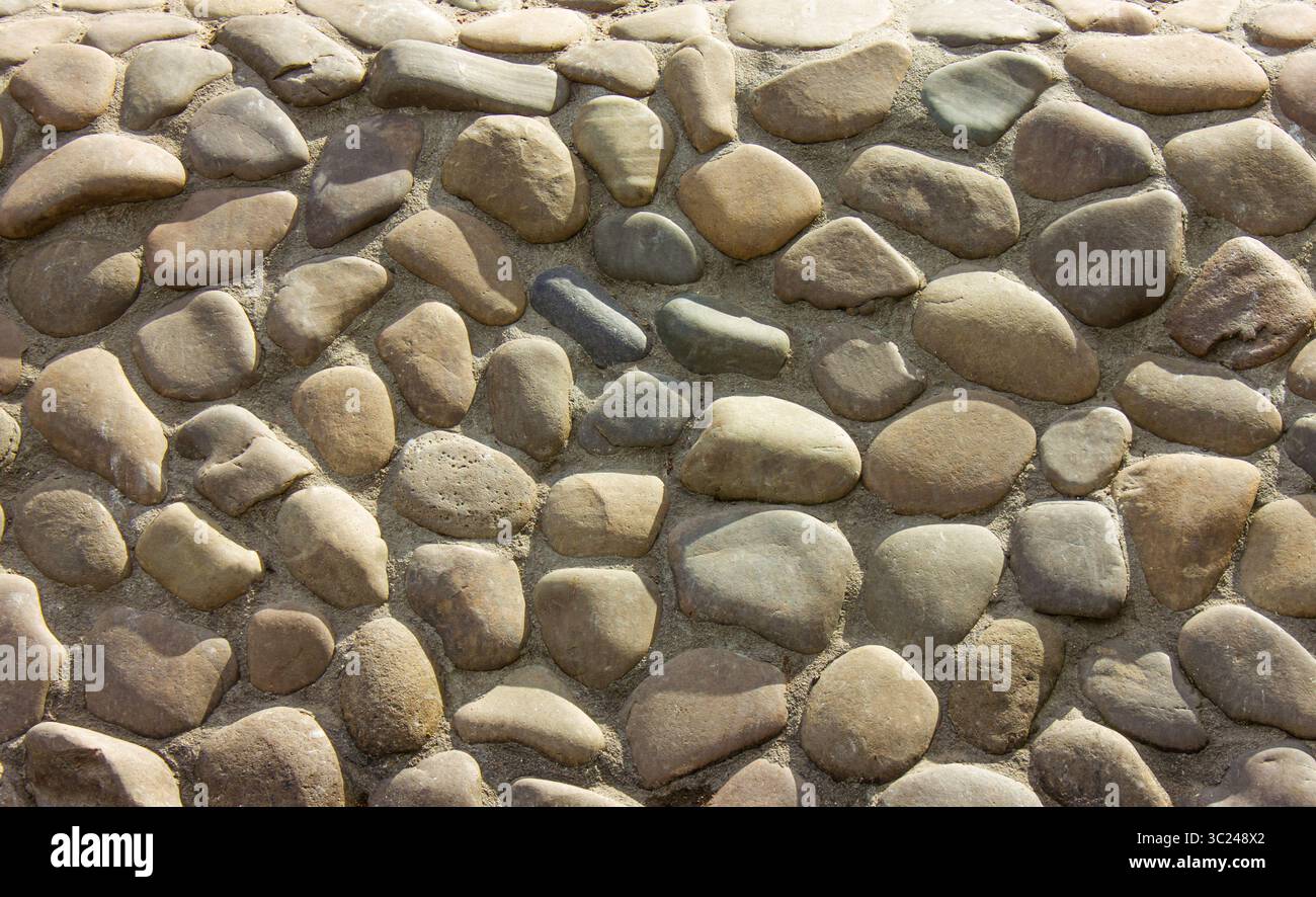 Abstrakter Hintergrund mit runden Kieselsteinen. Wand rund Stein Gesteinsstruktur oder Hintergrund. Stockfoto