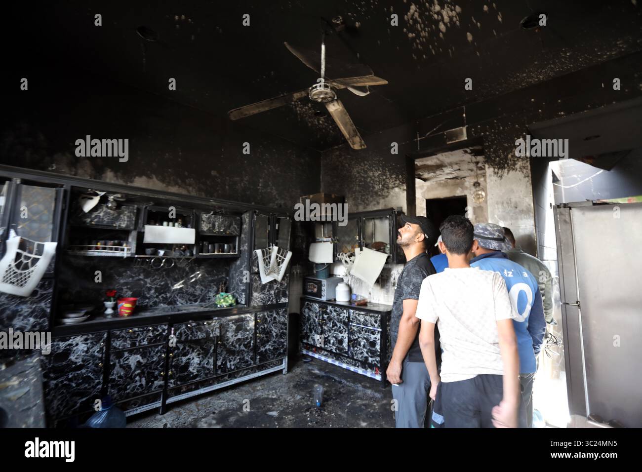 Bagdad, Irak. Juli 2025. Die Leute kontrollieren ein Haus nach einem Brand in Bagdad, Irak, am 23. Juli 2025. Am Mittwoch brach in einem Zivilhaus im Osten Bagdads ein Feuer aus, bei dem mindestens vier Menschen getötet und zwei weitere schwer verletzt wurden, sagte das irakische Innenministerium gegenüber Xinhua. Quelle: Khalil Dawood/Xinhua/Alamy Live News Stockfoto