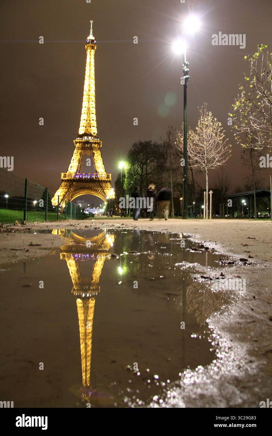 Der nächtliche eiffelturm spiegelt sich in einer Pfütze Stockfoto