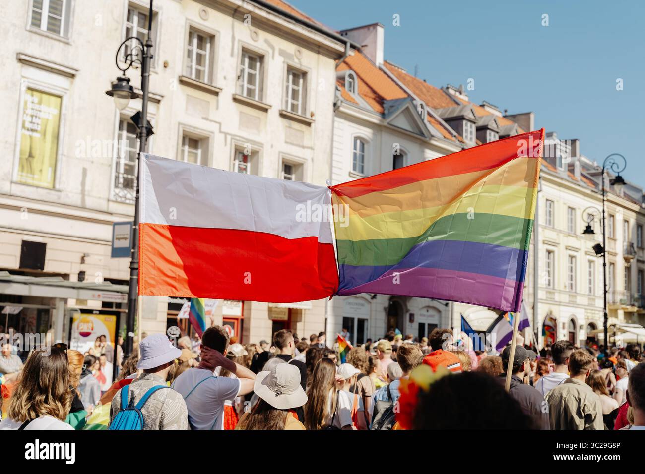 Ein Demonstrant schwingt eine polnische Flagge und ein anderer hält während der Parade eine LGBTQ+-Flagge. Die Equality Parade 2025 war der Höhepunkt der cityís-Pride-Feierlichkeiten, bei denen Tausende sich für LGBTQ+-Rechte einsetzten und Vielfalt und Integration zelebrierten. Stockfoto