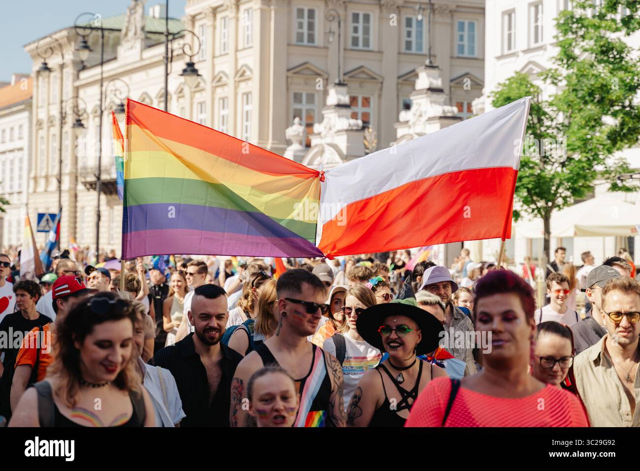 Ein Demonstrant schwingt eine polnische Flagge und ein anderer hält während der Parade eine LGBTQ+-Flagge. Die Equality Parade 2025 war der Höhepunkt der cityís-Pride-Feierlichkeiten, bei denen Tausende sich für LGBTQ+-Rechte einsetzten und Vielfalt und Integration zelebrierten. Stockfoto
