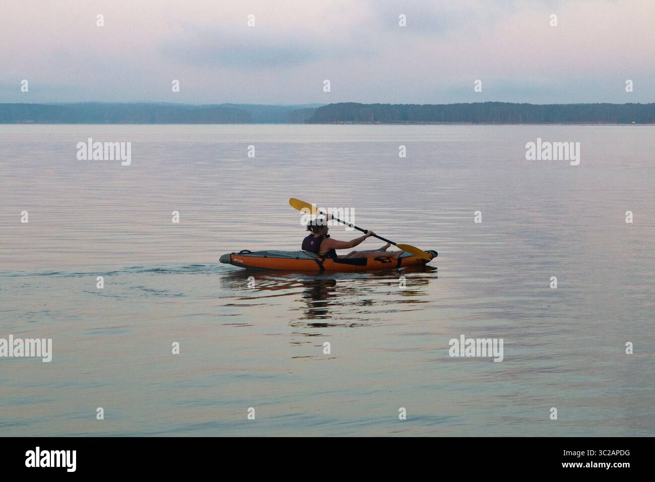 Kajakfahrer auf dem friedlichen See Stockfoto