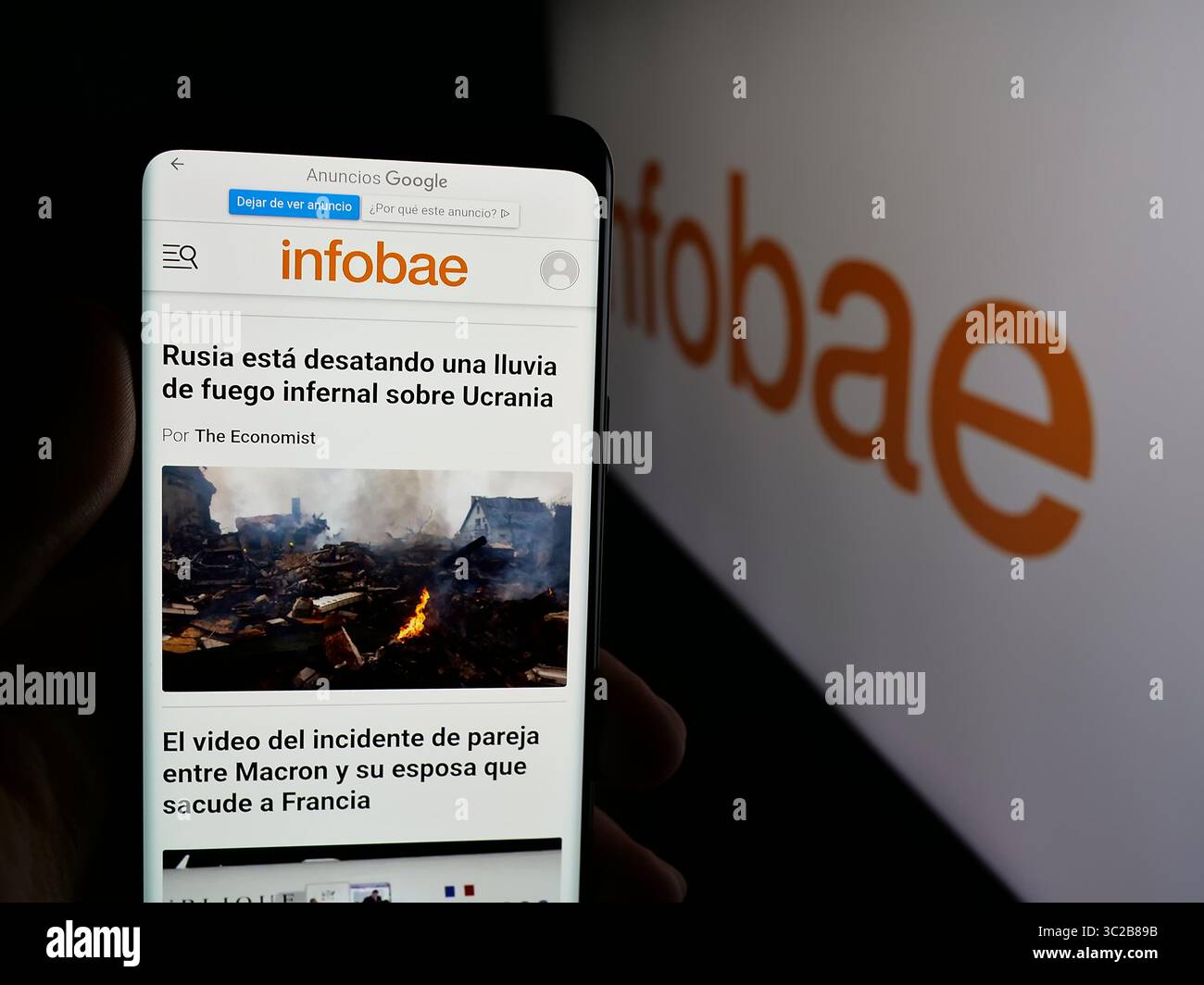Stuttgart, Deutschland - 27.05.2025: Person mit Smartphone und Webseite der argentinischen Online-Zeitung Infobae auf dem Bildschirm vor dem Logo. Stockfoto