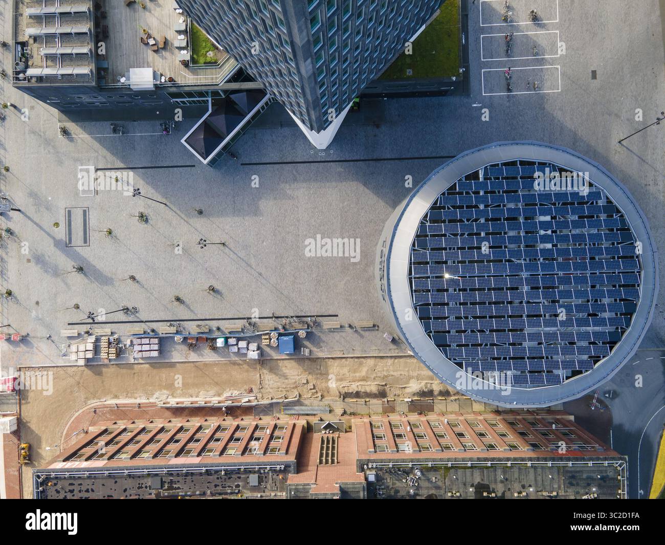 Aus der Vogelperspektive das fesselnde Zusammenspiel von moderner Architektur und urbanem Design, mit einem kreisförmigen Gebäude mit Solarpaneelen, Amsterdam, Nordholland, Niederlande. Stockfoto