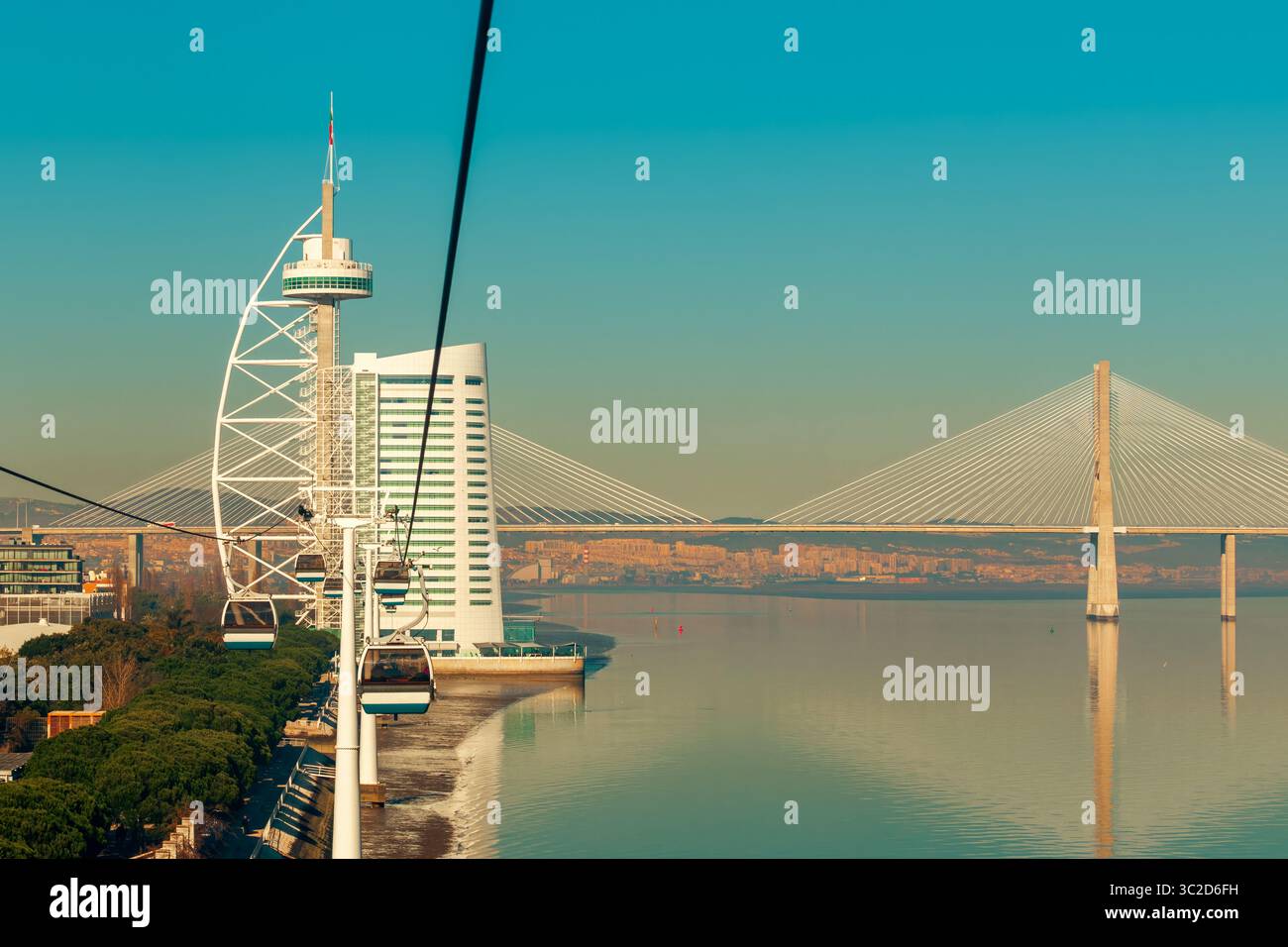 Aus der Vogelperspektive auf den Vasco da Gama-Turm und die Brücke über den Tejo. In Lissabon, Portugal, sind im Vordergrund Seilbahnen zu sehen. Stockfoto