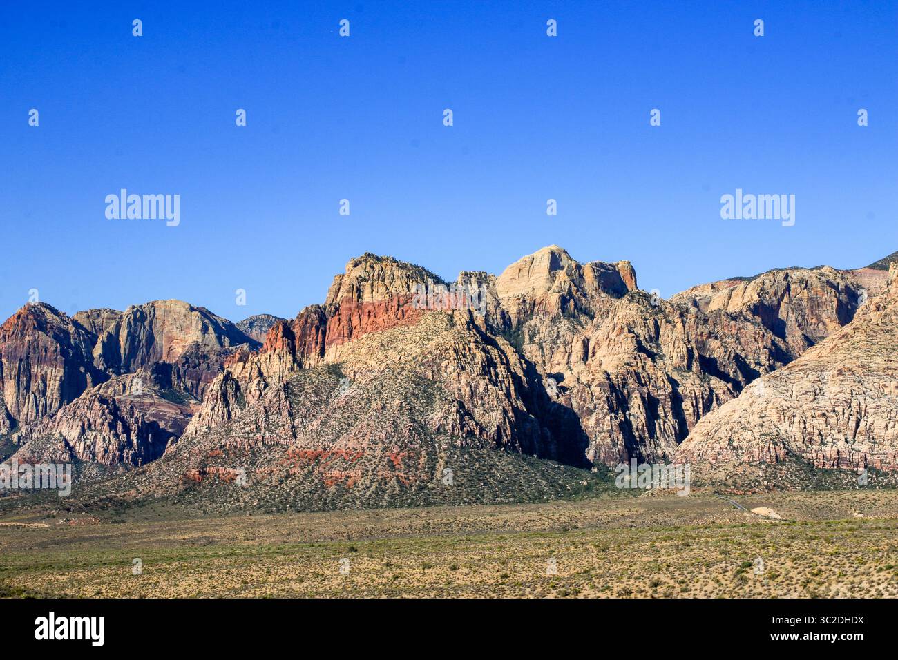 Weitläufige Wüstenlandschaft mit beeindruckenden roten Felsenbergen mit lebhaften Farben. Stockfoto