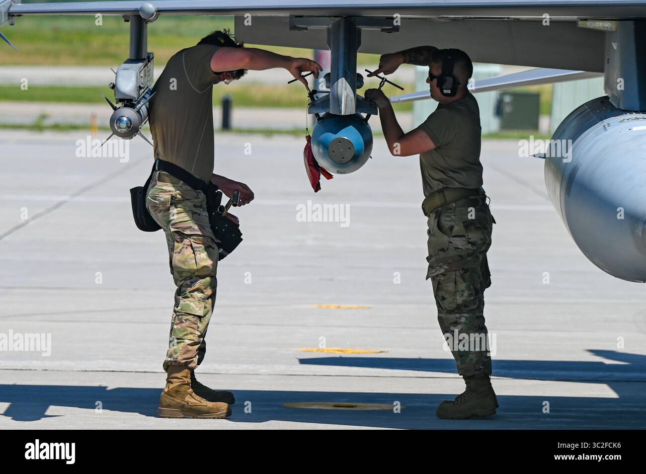 US Air Force Senior Airman Jayson Humphrey, links und Tech. Sergeant Stephanie Trotz, Waffentechniker des 177. Kampfflügels, laden Sie eine Rakete auf eine F-1 Stockfoto