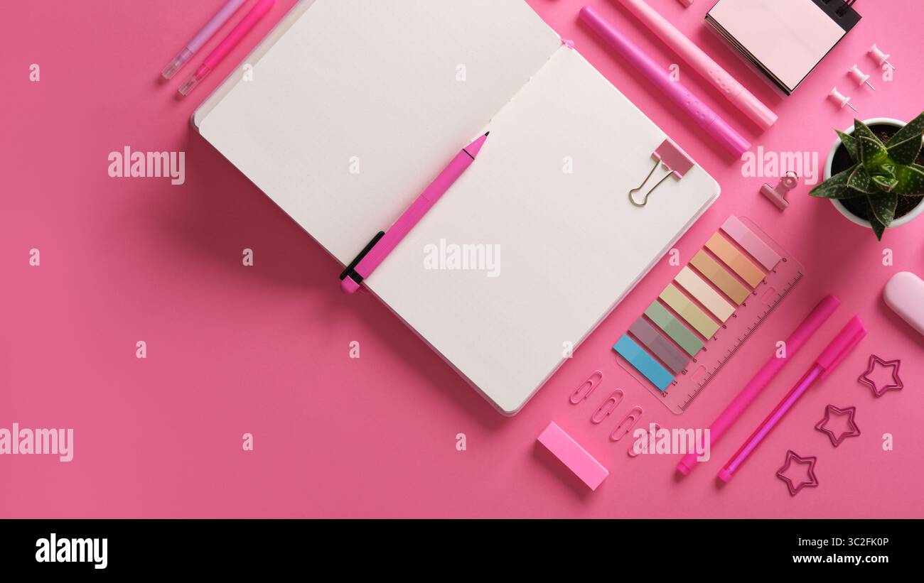 Horizontaler Schreibwarenhintergrund mit offenem Notizbuch mit Schreibwaren in rosa Thema. Stockfoto