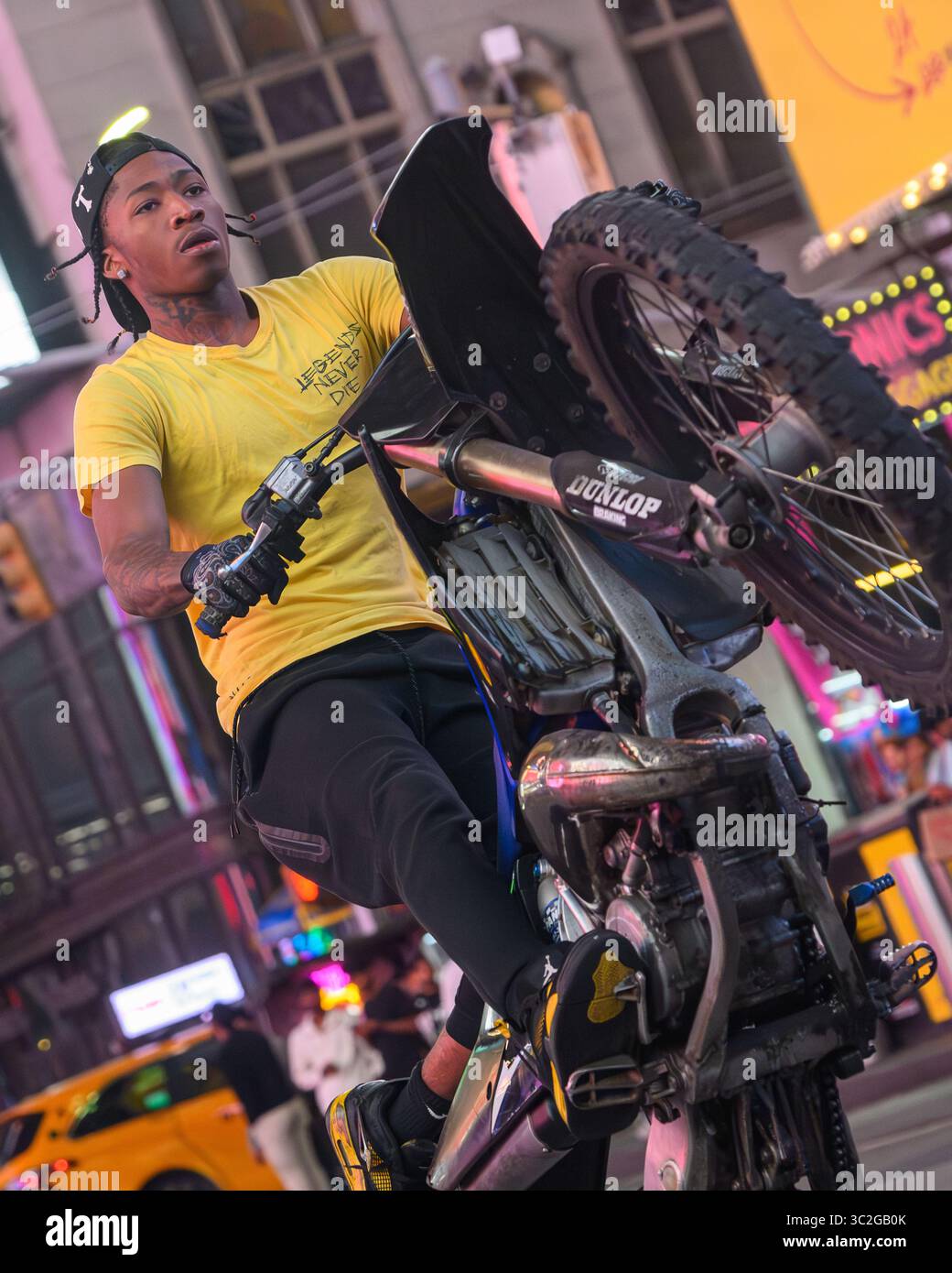Nahaufnahme eines Urban Moto Cross Rider, der Einen Wheelie auf der 7th Avenue am Times Square New York City zieht Stockfoto