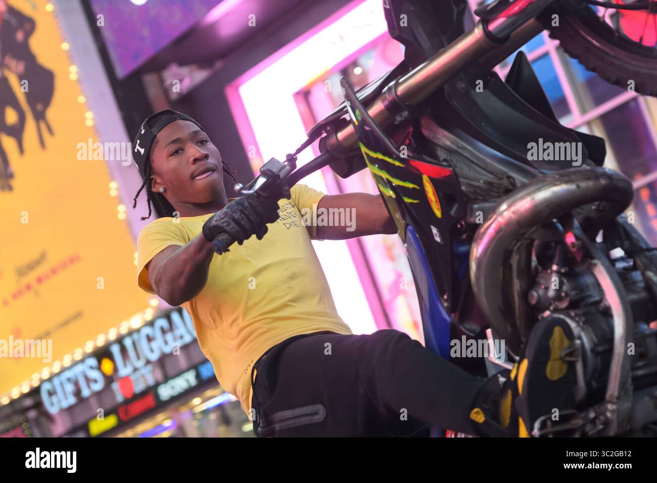 Nahaufnahme eines Urban Moto Cross Rider, der Einen Wheelie auf der 7th Ave am Times Square New York City zieht Stockfoto