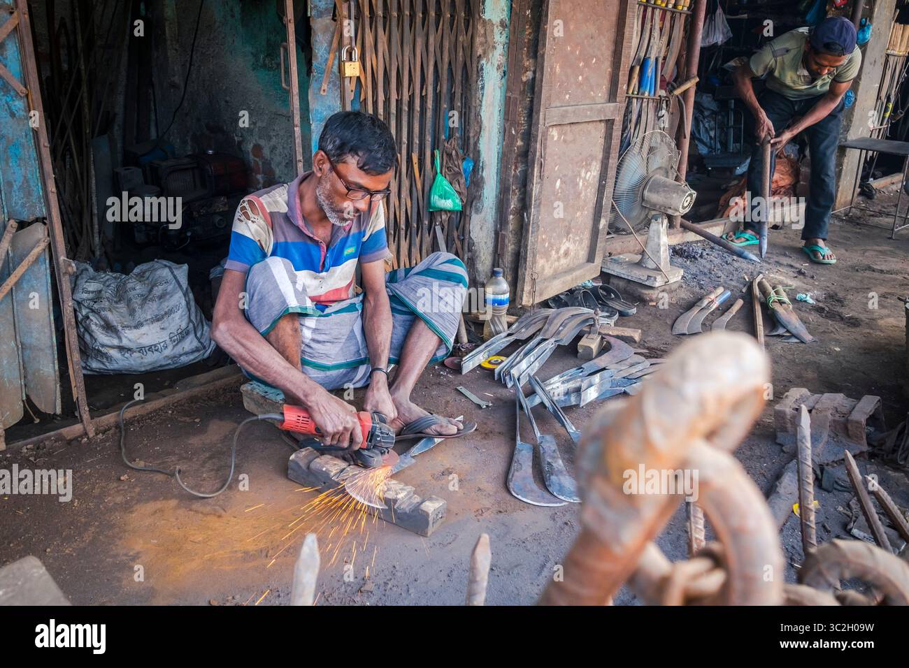 17. Januar 2019, Cox's Bazar, Bangladesch: Der Mann arbeitet ohne Schutzausrüstung mit der Mühle in der kleinen örtlichen Metallwerkstatt. Die Sicherheit am Arbeitsplatz steht auf der Tagesordnung der Regierung von Bangladesch, da viele Menschen seit der Katastrophe in Rana Plaza die Arbeitsbedingungen im Land in Frage stellen. 2 Millionen junge Menschen kommen jedes Jahr auf den Arbeitsmarkt, sowohl formell als auch informell, weshalb dringend ein besseres Arbeitsaufsichtsmanagement und eine bessere Arbeitssicherheit erforderlich sind. (Bild: © Robert Pastryk/ZUMA Wire) Stockfoto