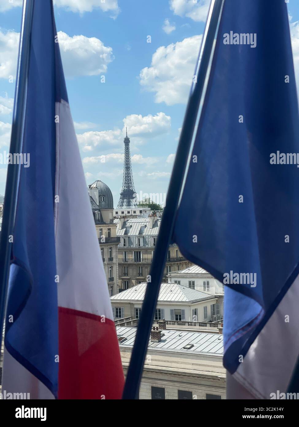 Paris Frankreich 9. Mai 2025. Malerischer Blick auf den Eiffelturm zwischen zwei französischen Flaggen in Paris. Die ikonische Struktur ist vor dem wunderschönen Himmel festgehalten, h Stockfoto