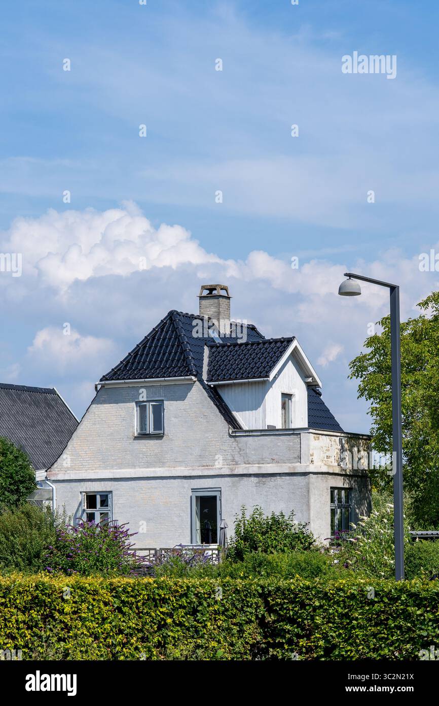 Bezauberndes dänisches Haus mit dunklem Kacheldach am sonnigen Tag Stockfoto