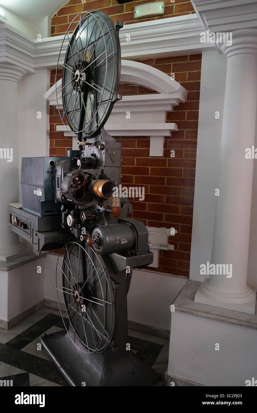 Ein klassischer 35-mm-Filmprojektor CX 21H in einem Kino im Vintage-Stil, umgeben von Säulen und roten Backsteinen, repräsentiert Retro-Filmtechnologie Stockfoto