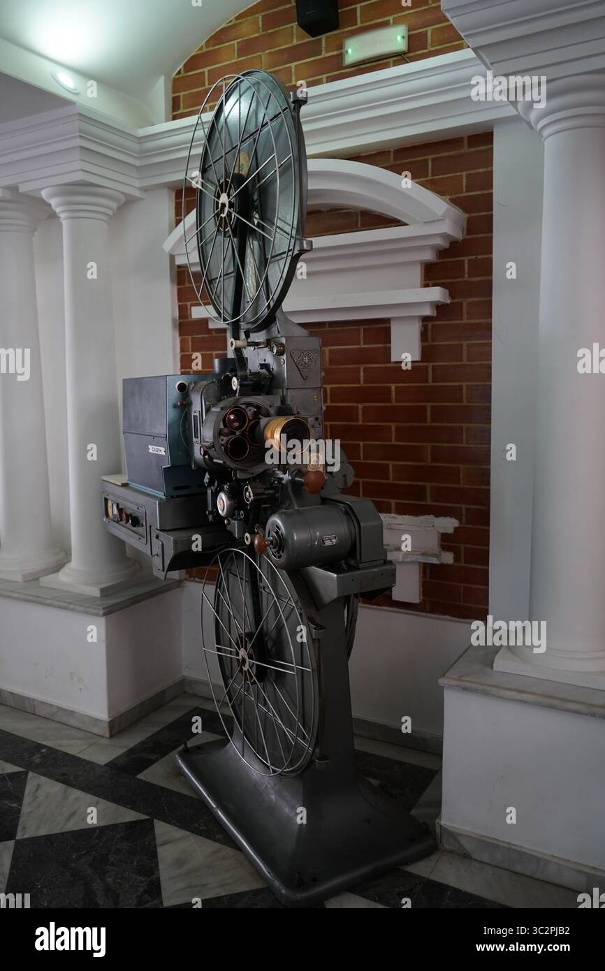 Ein klassischer 35-mm-Filmprojektor CX 21H in einem Kino im Vintage-Stil, umgeben von Säulen und roten Backsteinen, repräsentiert Retro-Filmtechnologie Stockfoto