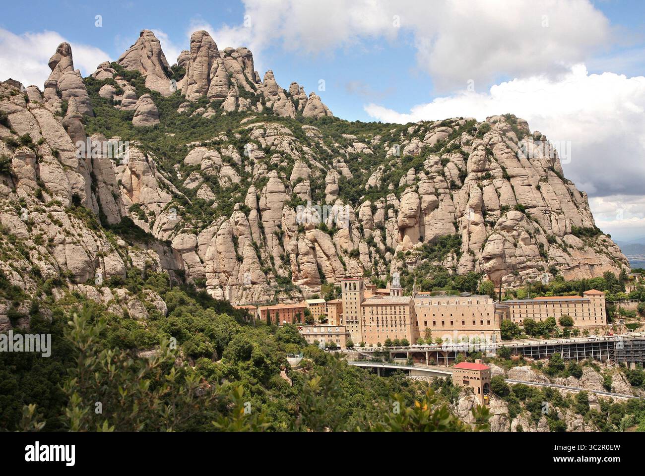 15. Juli 2019, Montserrat, Spanien: Felsige Hänge des Massivs mit interessanten Felsformen. Benediktinerabtei Santa Maria de Montserrat. Das Kloster ist bekannt für die Kultfigur der Jungfrau Maria (La Moreneta). Die Figur der Mutter Gottes ist aus hunderten von Jahren verbrannten Kerzen geschwärzt und befindet sich in einer Nische über dem Hauptaltar der Basilika. Im Kloster gibt es eine Schule, eine Pension für Jungen und Jungen von Gregorian, eine der ältesten in Europa, genannt Escolania de Montserrat. (Kreditbild: © Damian Klamka/SOPA Images via ZUMA Wire) Stockfoto