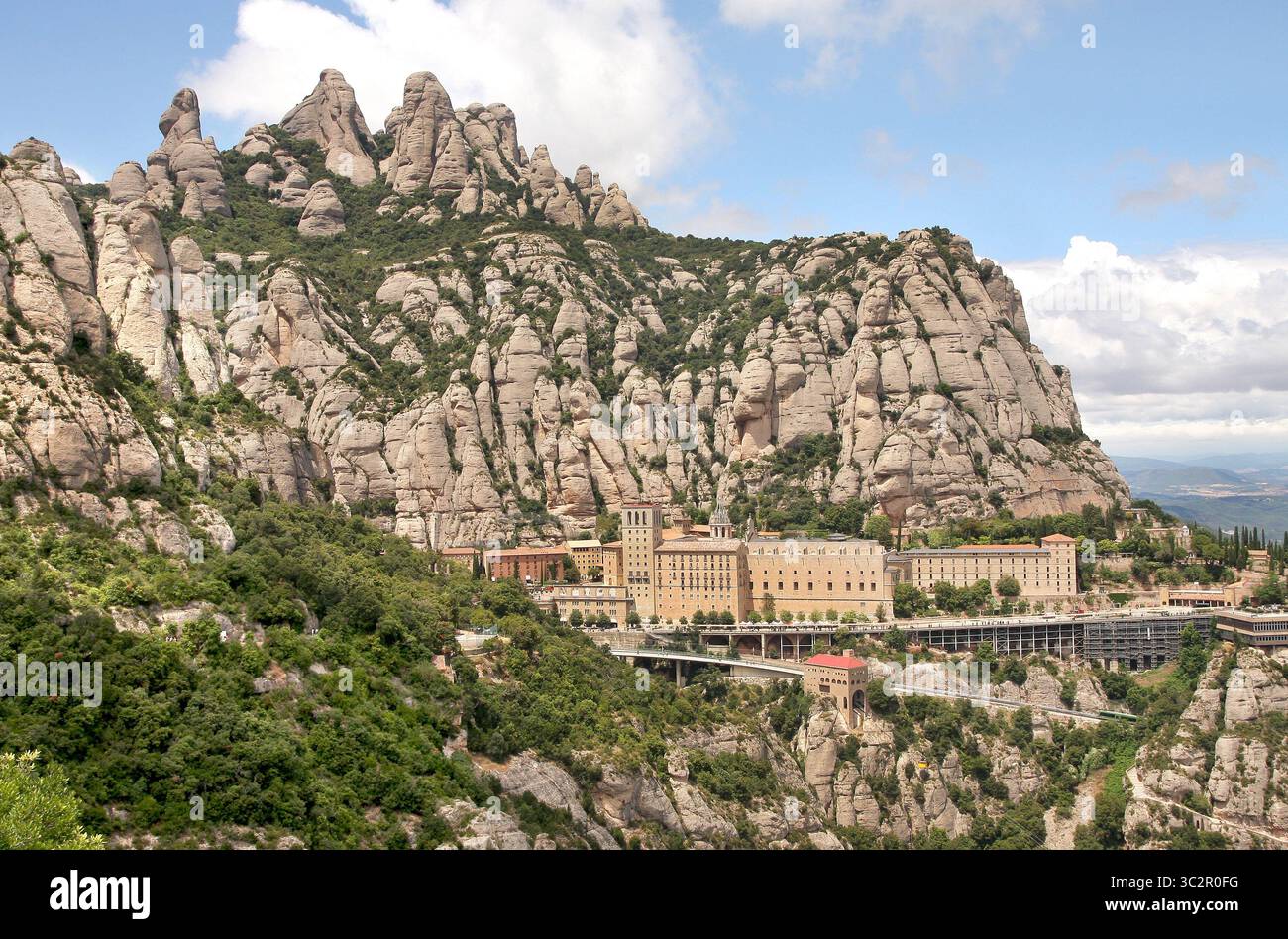 15. Juli 2019, Montserrat, Spanien: Felsige Hänge des Massivs mit interessanten Felsformen. Benediktinerabtei Santa Maria de Montserrat. Das Kloster ist bekannt für die Kultfigur der Jungfrau Maria (La Moreneta). Die Figur der Mutter Gottes ist aus hunderten von Jahren verbrannten Kerzen geschwärzt und befindet sich in einer Nische über dem Hauptaltar der Basilika. Im Kloster gibt es eine Schule, eine Pension für Jungen und Jungen von Gregorian, eine der ältesten in Europa, genannt Escolania de Montserrat. (Kreditbild: © Damian Klamka/SOPA Images via ZUMA Wire) Stockfoto