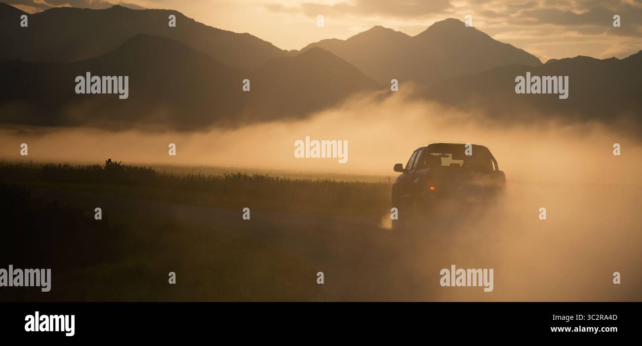 Pick Truck Car in Bewegung auf einer Landstraße mit Staubwolken. SUV fahren schnell auf der Landstraße. Überquerung in der Wüste Stockfoto