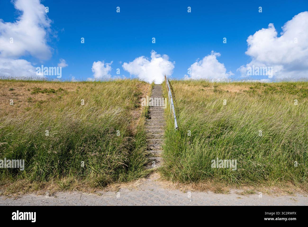 Betontreppe mit Geländer auf einem Deich Stockfoto