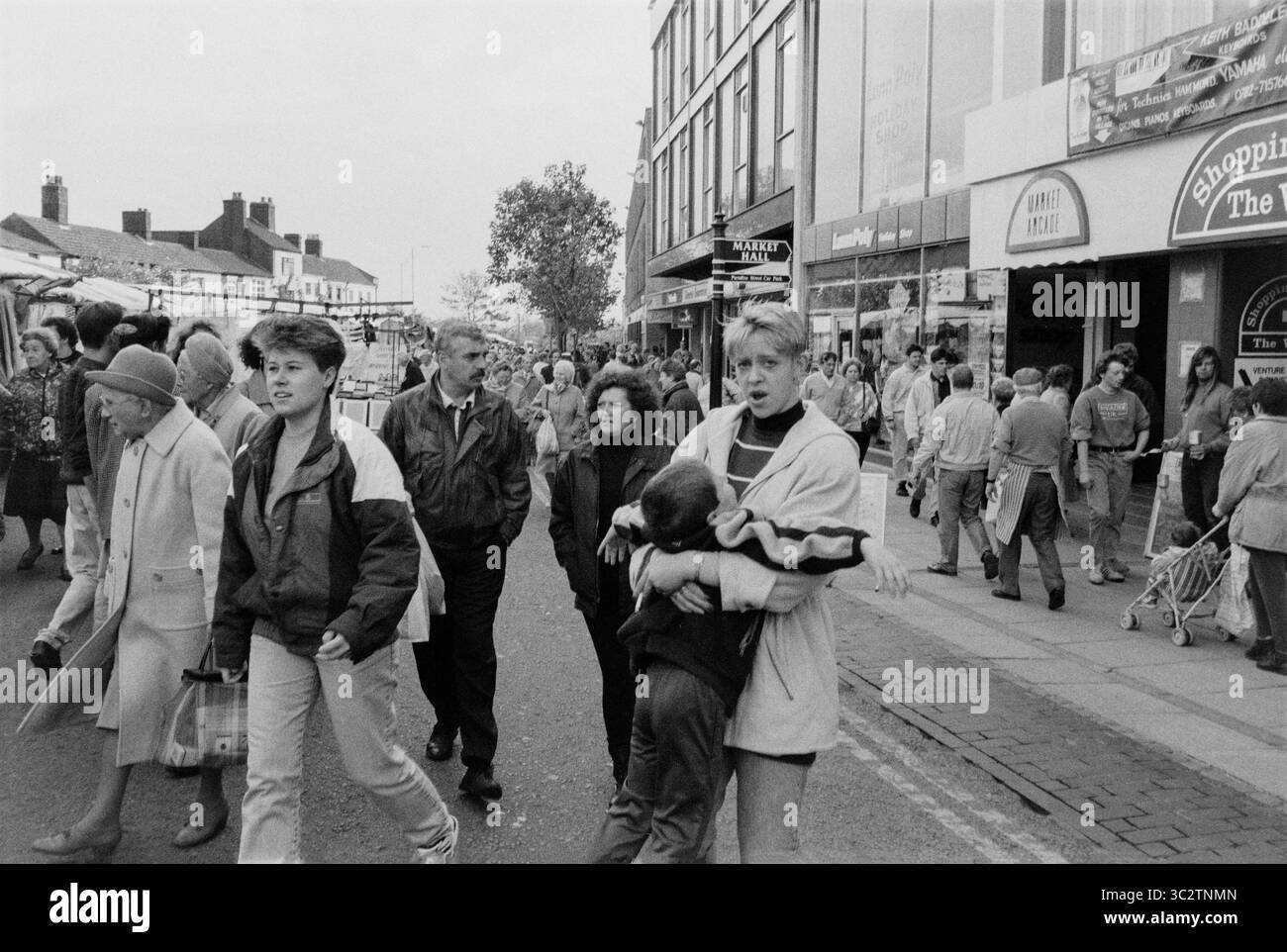NEWCASTLE-UNDER-LYME, STAFFORDSHIRE, ENGLAND, Großbritannien - 1993 - Straßenszene mit einem geschäftigen Markttag in Newcastle-under-Lyme, Staffordshire, England, Vereinigtes Königreich - Stockfoto