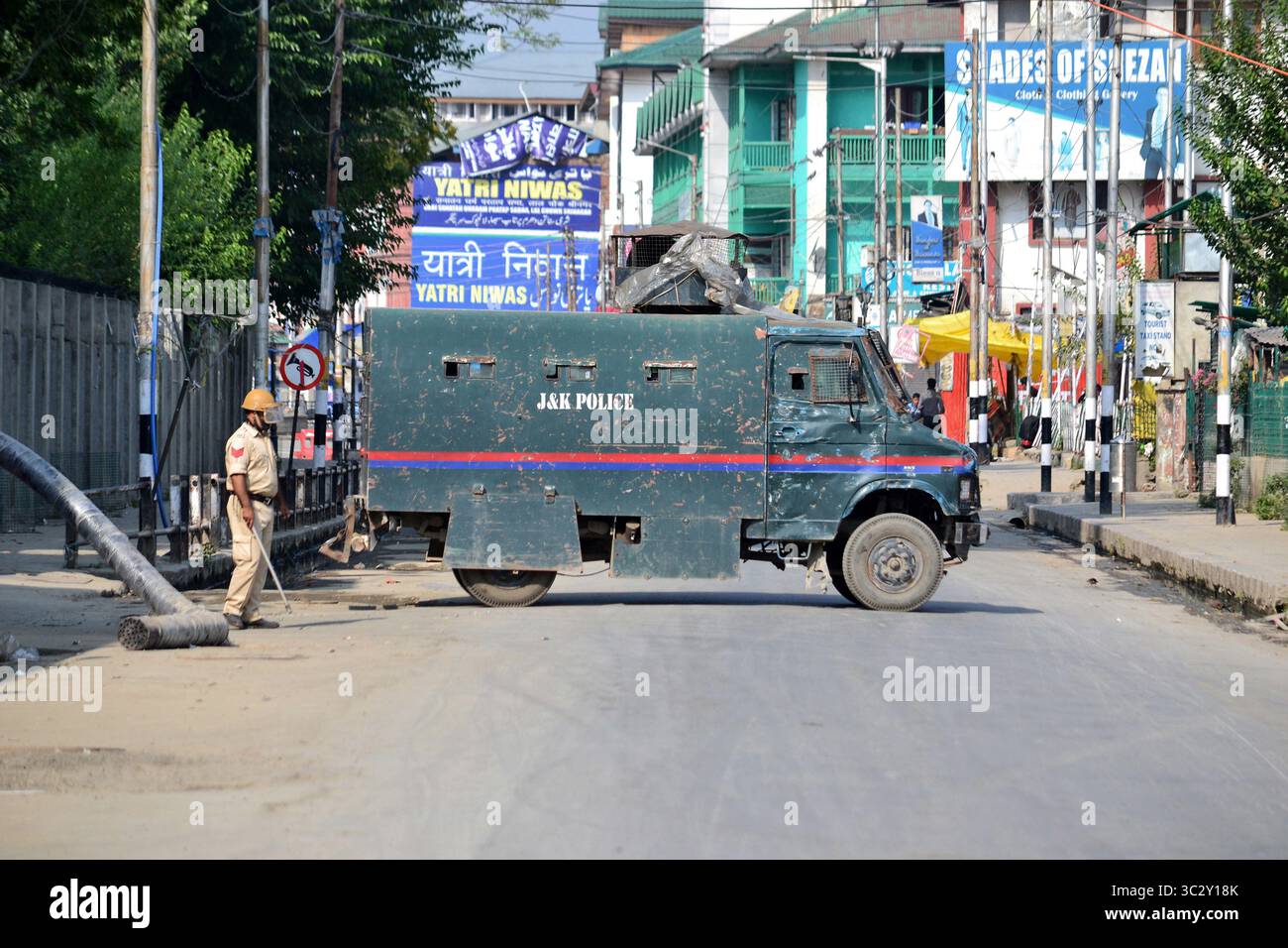 16. August 2019, Srinagar, Jammu und Kaschmir, Indien: Ein Polizist steht neben einem gepanzerten Fahrzeug während der Ausgangssperre in Srinagar. Strenge Ausgangssperre und ein vollständiger Kommunikationsausfall im Kaschmir-Tal, nachdem die Zentralregierung beschlossen hatte, artikel 370, der Jammu & Kaschmir einen Sonderstatus gewährt, zu streichen. (Kreditbild: © Saqib Majeed/SOPA Bilder via ZUMA Wire) Stockfoto