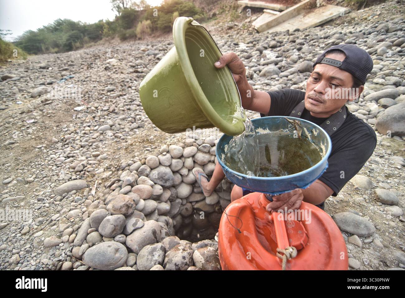 27. August 2019, Bekasi, West-Java, Indonesien: Ein Bewohner sammelt Wasser aus einem trockenen Cipamingkis-Fluss für den Hausgebrauch, da seine Brunnen aufgrund der Dürre in der Sommersaison austrocknen. Die Agentur für Meteorologie, Klimatologie und Geophysik hat gewarnt, dass die Trockenzeit aufgrund des El NiÃ±o-Phänomens trockener und intensiver sein könnte als letztes Jahr. Die Agentur stufte West-Java, Zentral-Java, die meisten Teile Ostjavas, Yogyakarta, Bali und Nusa Tenggara als die am stärksten von extremer Dürre bedrohten areaâ ein oder mehr als 60 Tage ohne Regen. (Credit Image: © Agung Fatma Putra/SOPA Images via ZUMA Wire) Stockfoto