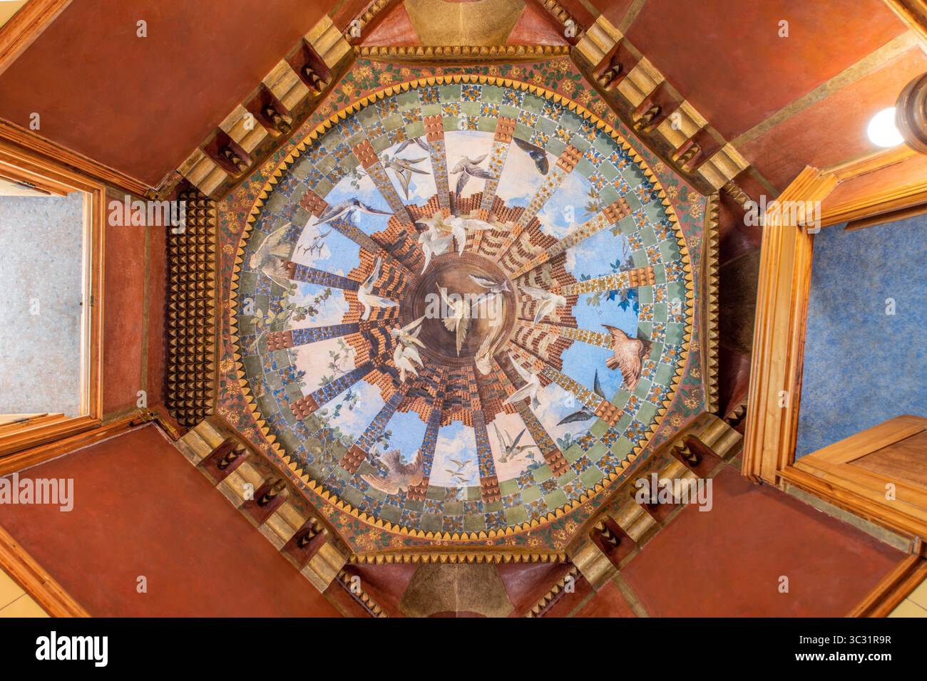 Kunstvolle Deckenmalerei in der Casa Vicens, die Antoni Gaudi von der Natur inspirierte moderne Kunst zeigt. Kreisförmiges Design, hoch aufragende Vögel, blauer Himmel, kompliziert Stockfoto