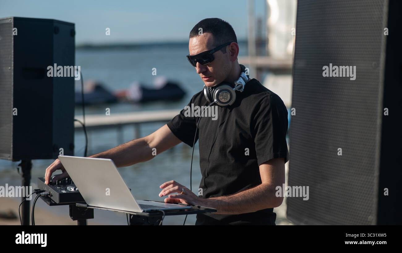 Kaukasier arbeitet als DJ am Strand. Stockfoto