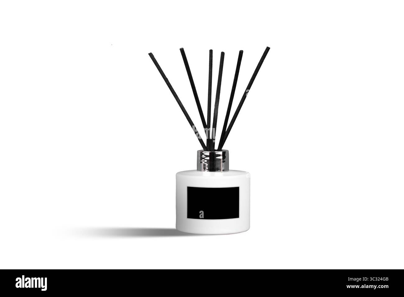 Duftdiffusor mit Schilf und ätherischen Ölen in einer weißen Flasche auf weißem Hintergrund und leerem schwarzen Etikett Stockfoto