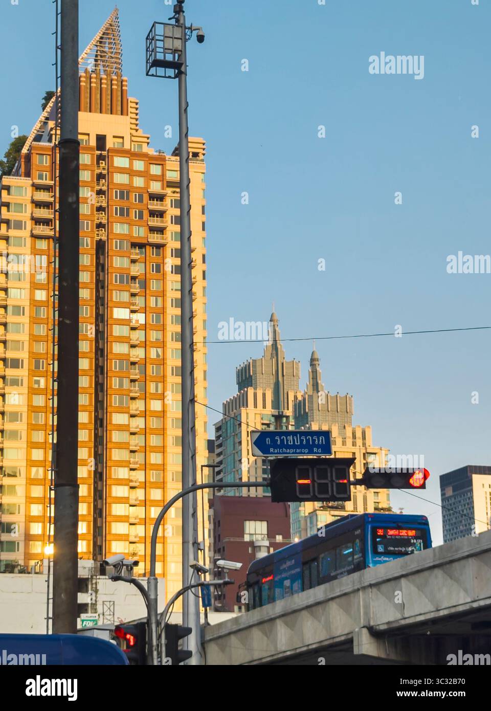 Bangkok,Thailand-07. April 2024-später Nachmittag, Sonnenlicht aus niedrigem Winkel wird zufällig von Hochhäusern reflektiert, während der Stadtverkehr im Schatten läuft Stockfoto