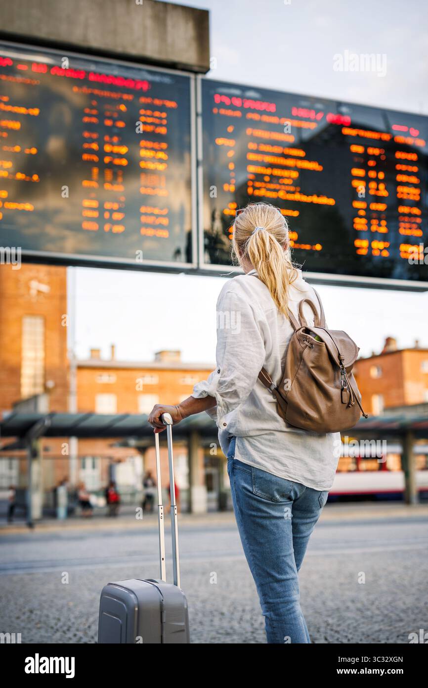 Alleinreisen im Urlaub. Die Passagierin überprüft den Fahrplan der Ankunft und Abfahrt am Busbahnhof Stockfoto