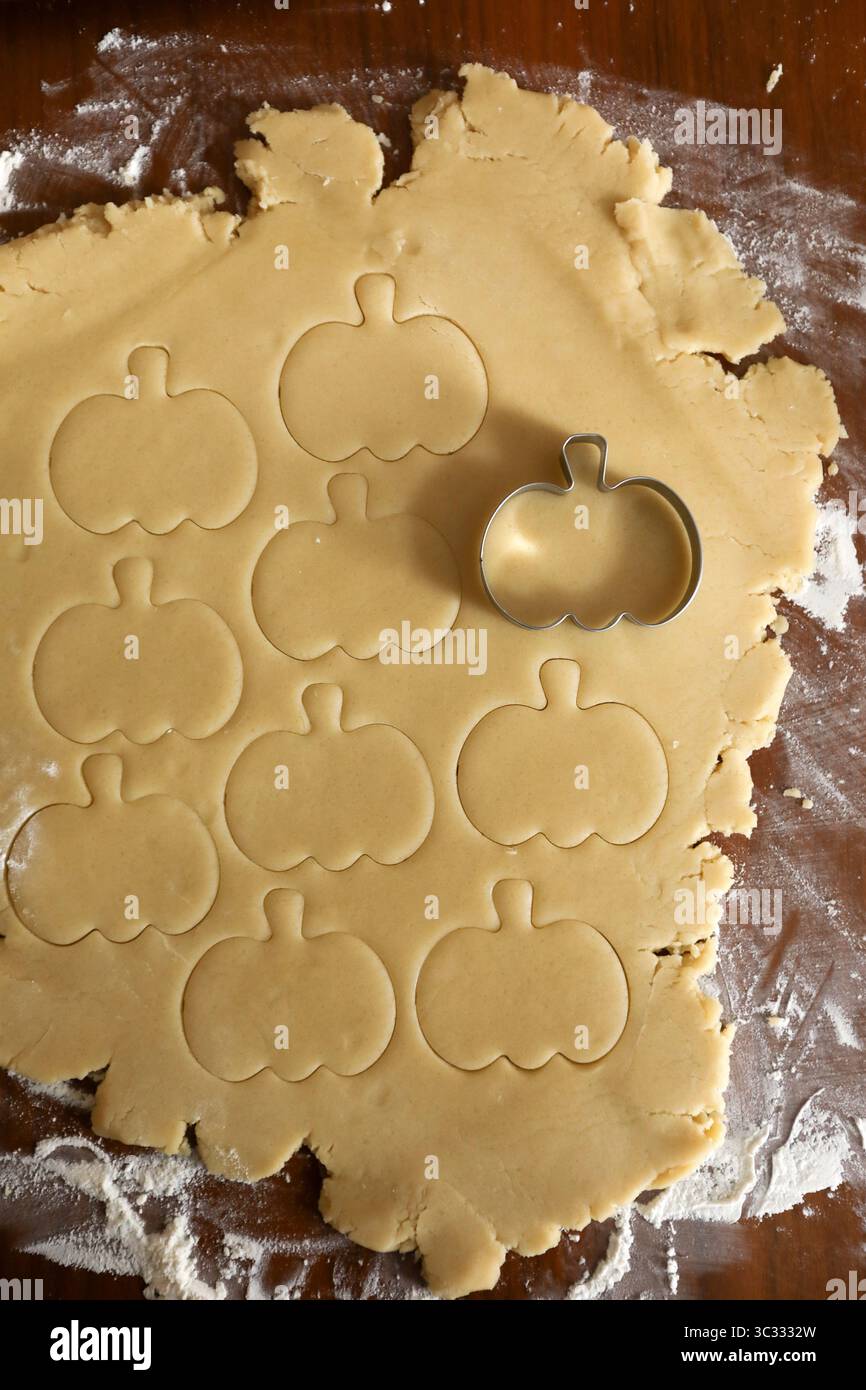 Schneiden Sie Kekskürbisformen in hausgemachten, gerollten Zuckerteig Stockfoto