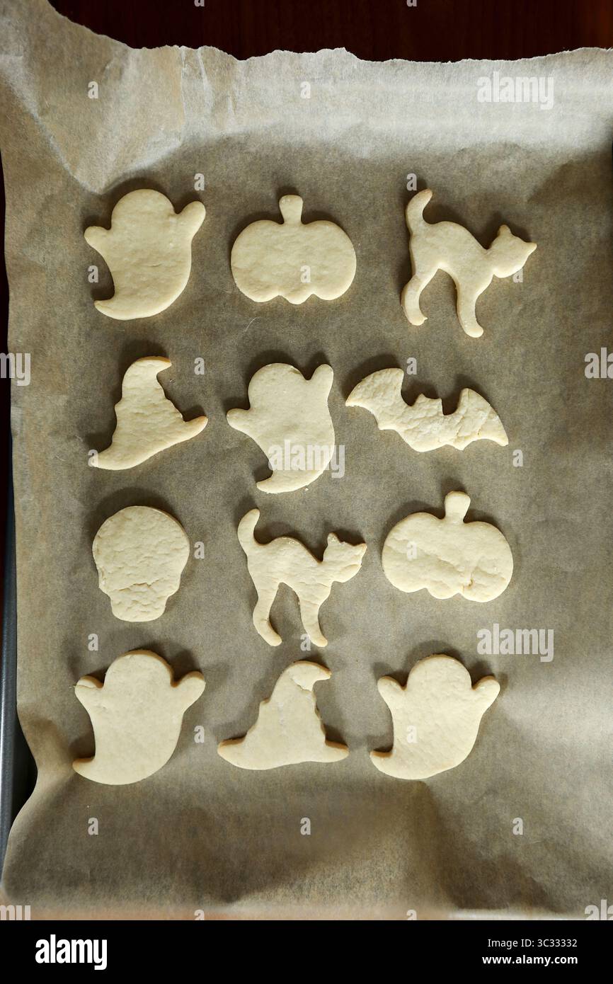 Frisch gebackene halloween-Keksformen auf braunem Pergamentpapier Stockfoto