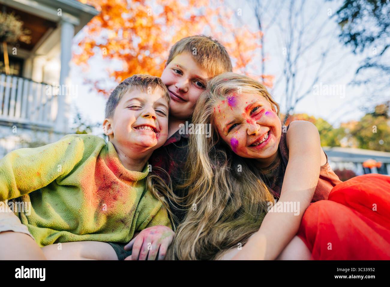 Kinder lächeln und in holi-Farben vor ihrem Haus bedeckt Stockfoto