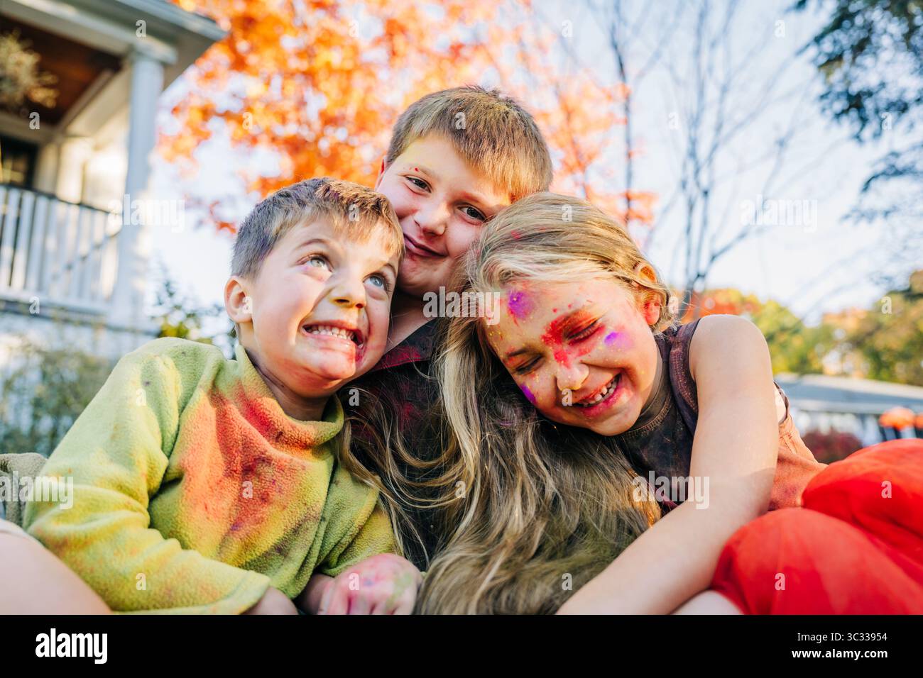 Drei glückliche Kinder, die in holi-Farben gelacht haben Stockfoto