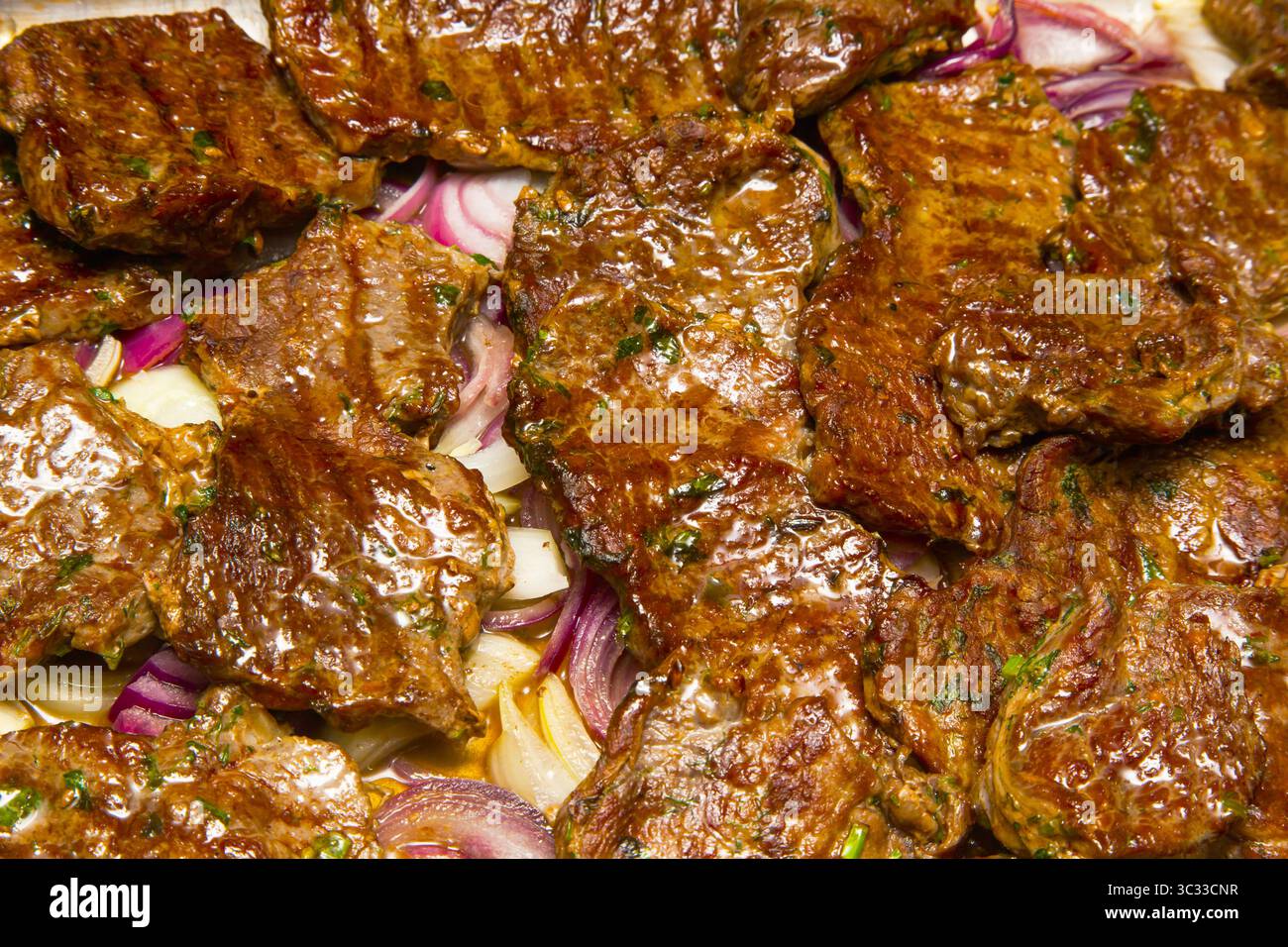 Frittiertes Rinderfilet mit Zwiebeln. Saftige gegrillte Fleischsteaks aus nächster Nähe. Stockfoto