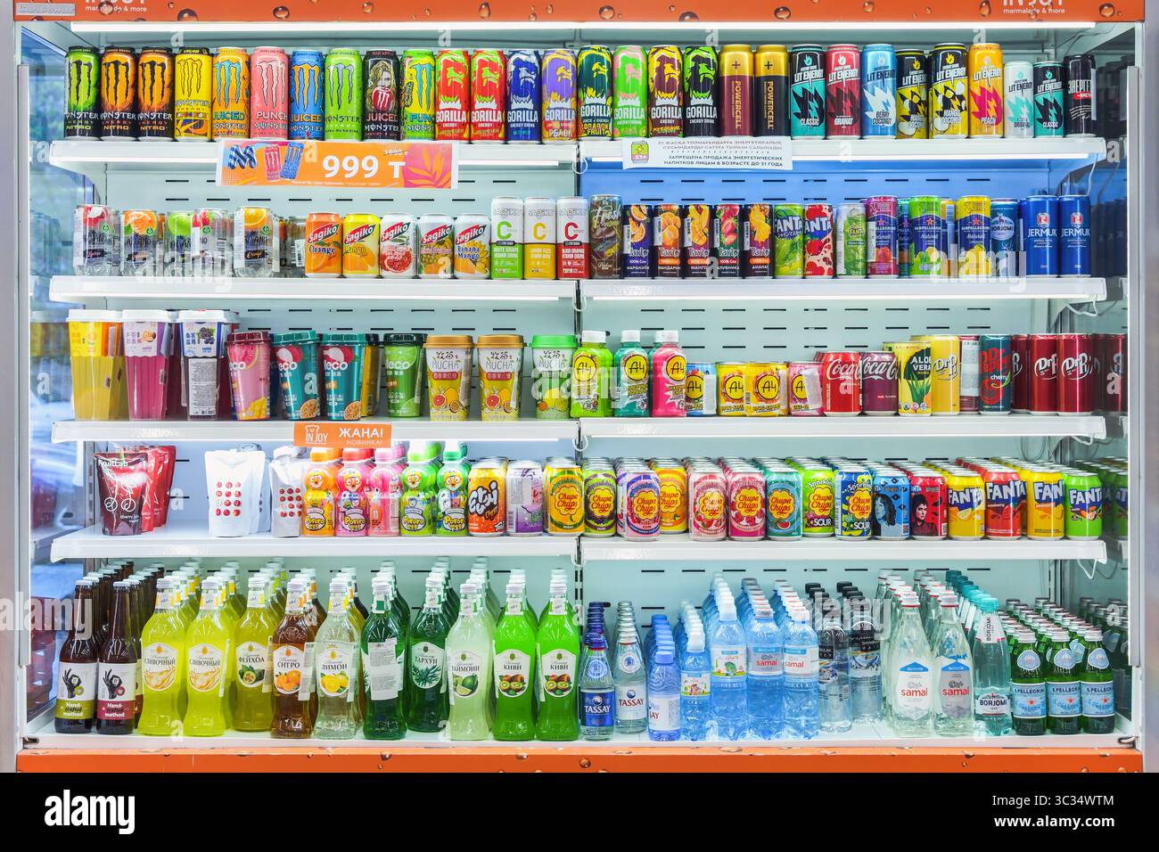 Almaty, Kasachstan - 08. Juli 2025: Alkoholfreie Getränke in den Regalen eines großen Kühlschranks. Erfrischende Säfte und Wasser. Heiße Jahreszeit Stockfoto