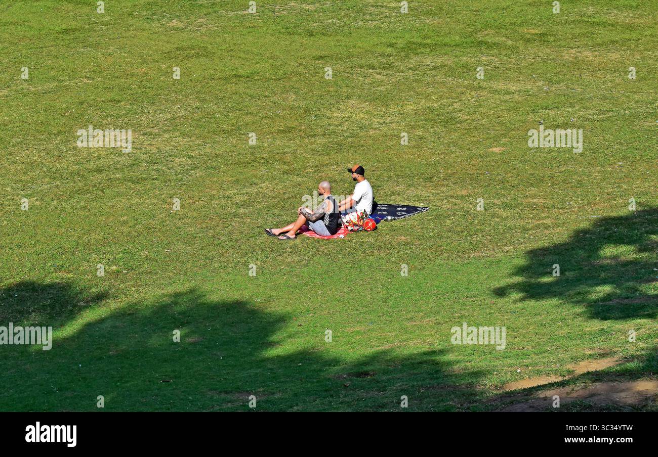 RIO DE JANEIRO, BRASILIEN - 19. Juni 2025: Zwei Männer sitzen auf dem Rasen in Quinta da Boa Vista Stockfoto