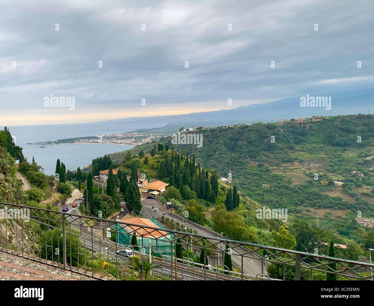 Terrazza Panoramica su Giardini Naxos bietet einen atemberaubenden Aussichtspunkt mit Blick auf die sizilianische Küste, glitzerndes blaues Meer, das sich bis zum Horizont erstreckt. Stockfoto