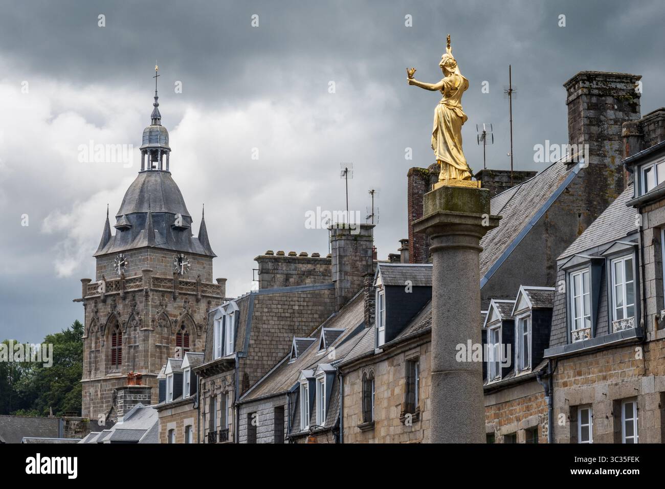 Glockenturm der Kirche Notre-Dame und Statue von Marianne (Allegory of the Republic) unter stürmischem Himmel in Villedieu-les-Poêles in der Normandie, Frankreich Stockfoto